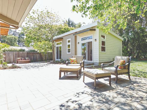 An ADU facing a backyard patio with furniture