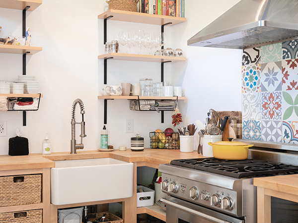 Modern kitchen with stove, sink and shelves in an ADU.