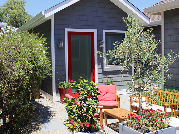 Blue ADU and a small courtyard with patio furniture.