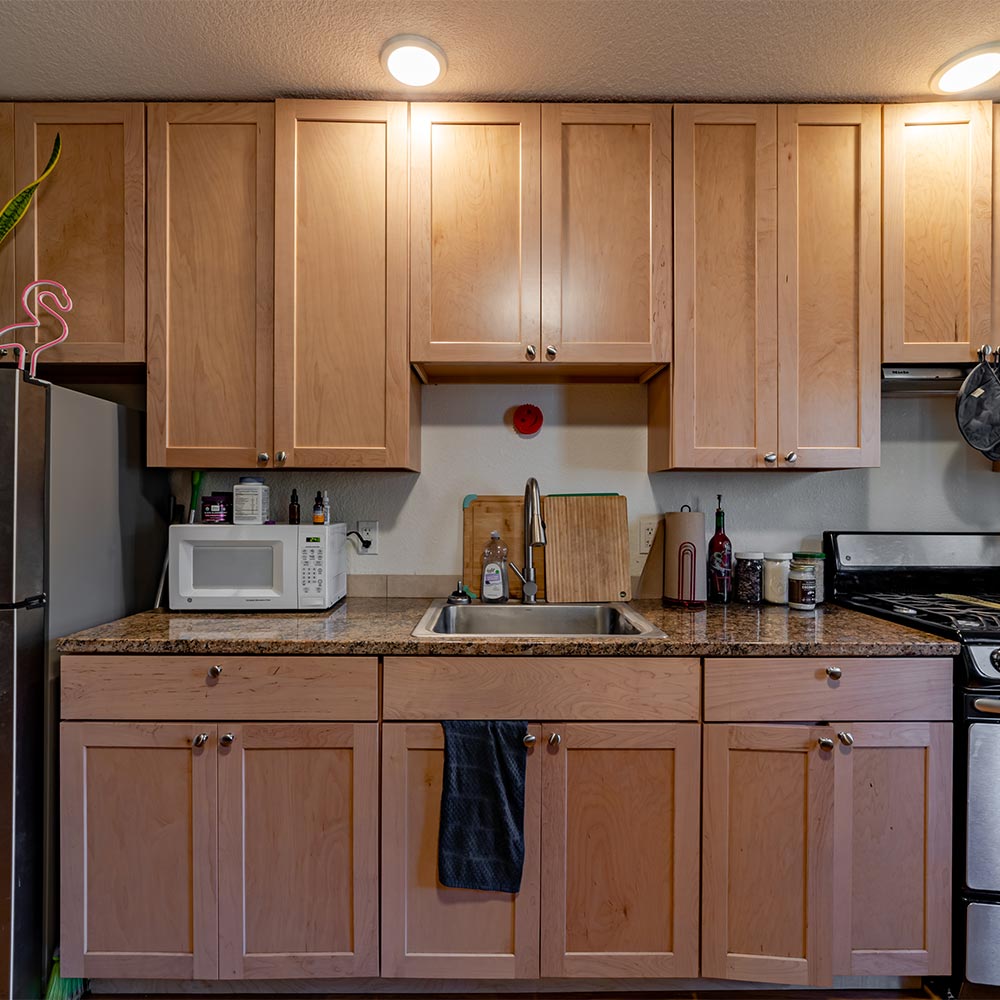 Kitchen inside of junior ADU with microwave, sink and cabinets.