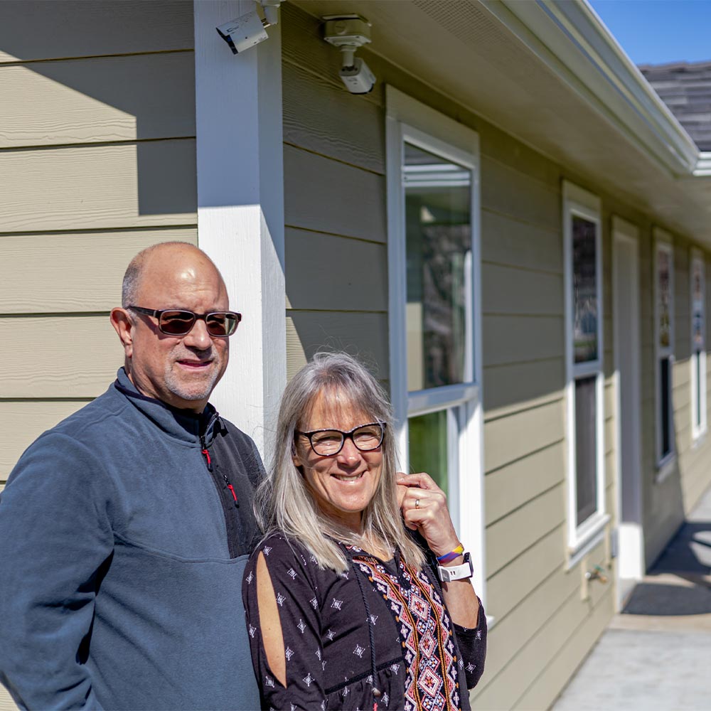 A man and a woman pose in front of their ADU.