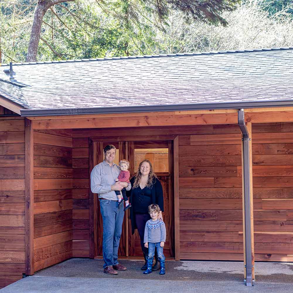 Thomas and Terra and their two children smiling at the entrance to the ADU.