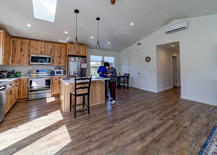 A man and a woman stand in the kitchen of an ADU.